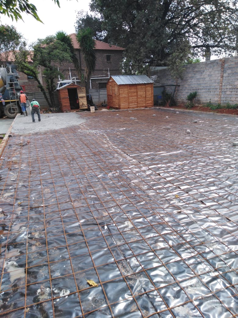 Reinforcement mesh laid over a concrete slab with damp-proofing ahead of the pour