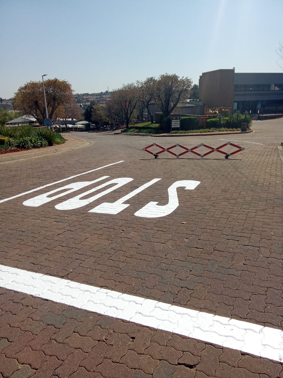 STOP marking and stop line painted on block paving at a road entrance