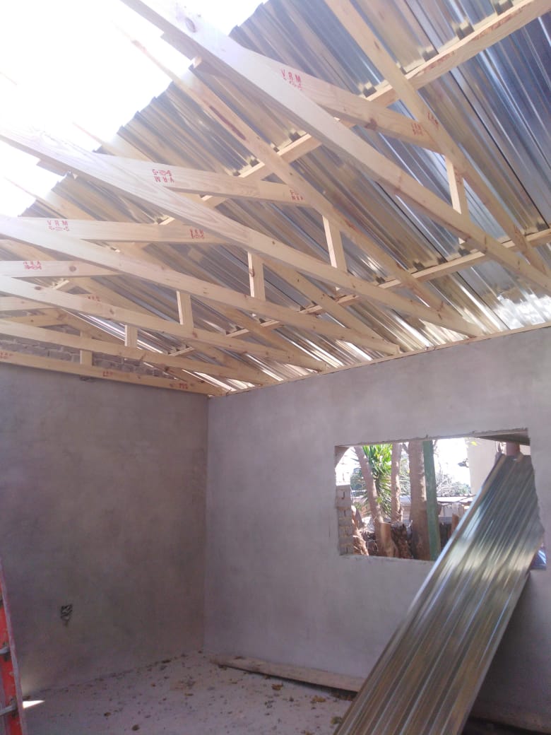 Roof trusses with sheeting being installed over an unfinished interior